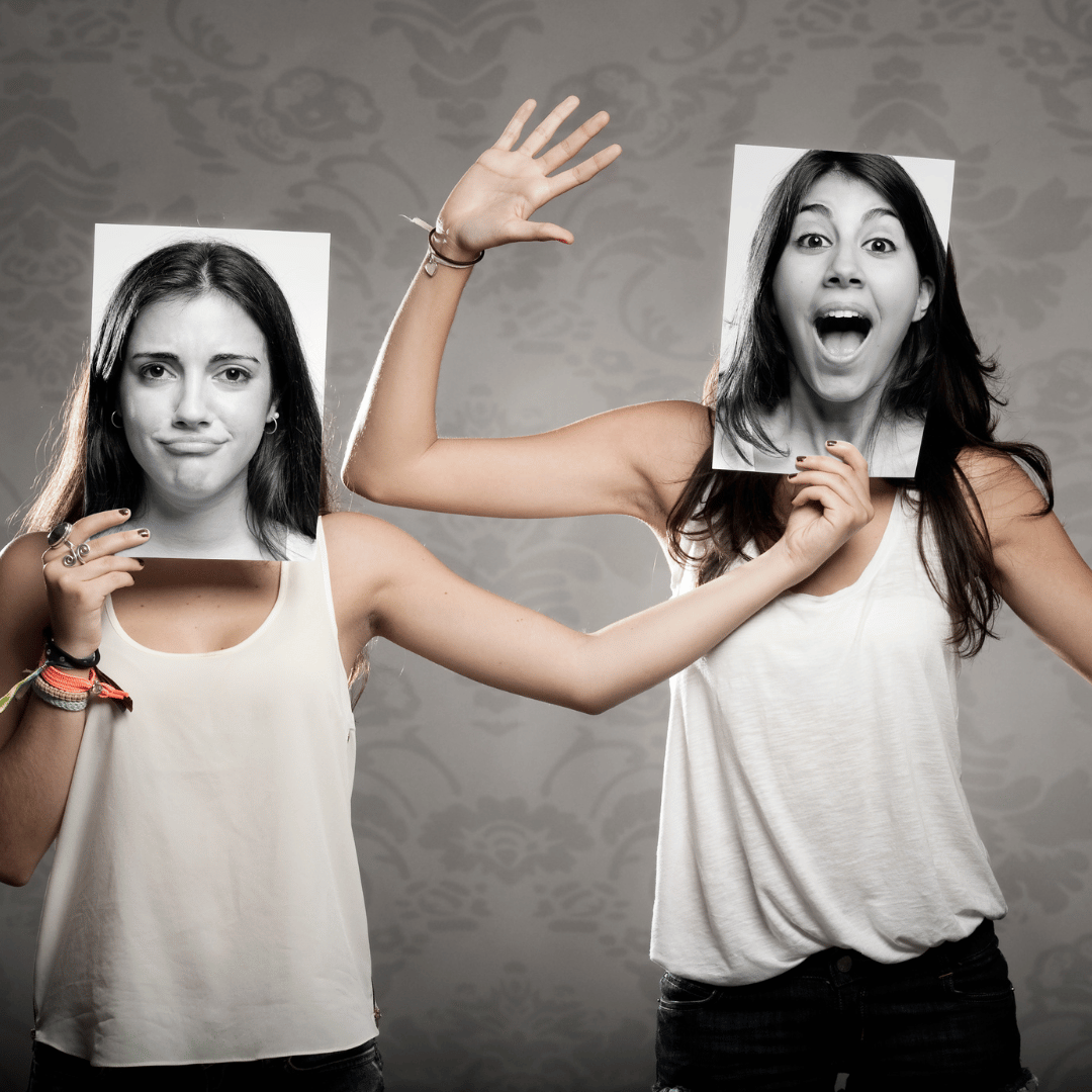 Two people holding up pictures of faces in front of their own faces, one with a sad expression and one with a surprised expression.