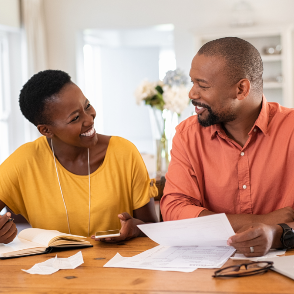 Happy couple sitting at a table reviewing their account statements