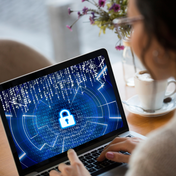 Person looking at a laptop displaying a lock on the screen to signify cybersecurity