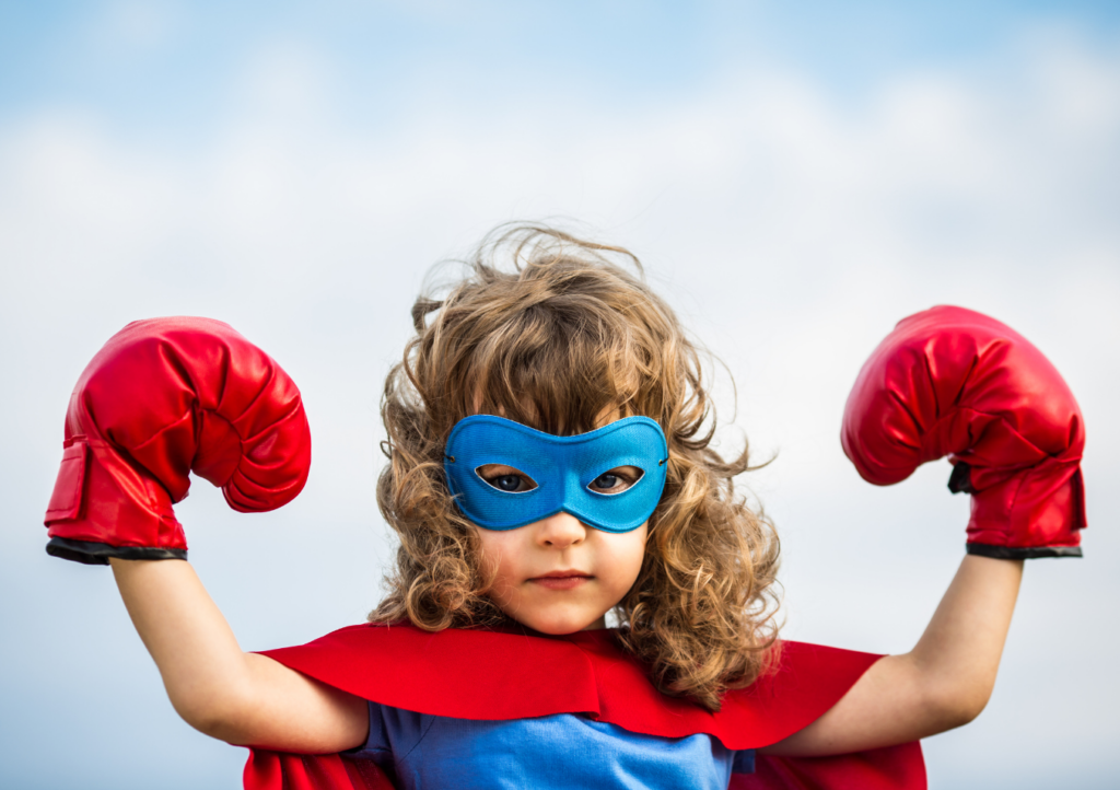 a child in a superhero costume and boxing gloves